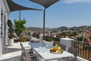 a table with a bowl of fruit on a balcony at Villa Val-Gio in Ermoupoli