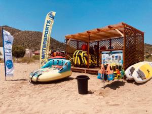 uma loja de surf na praia com pranchas de surf na areia em Goldfish Seaside Luxury Houses em Kómi