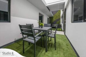 un patio con mesa y sillas en el césped en Studio8 Lujan Apartament # 2, en San José