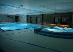 a large swimming pool with a tub in a building at Navy Blue Dream - SPA - Basen - Parking in Dziwnów