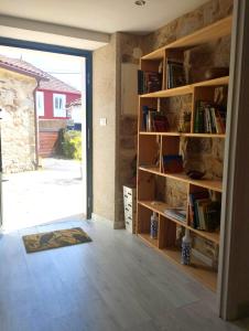 a room with bookshelves and a door leading to a yard at Casa Aldea de Abaixo in Lugo