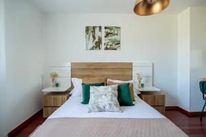 a bedroom with a large bed with green pillows at Wasi Compostela in Santiago de Compostela