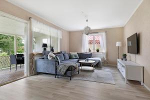 Guestly Homes - 5BR Corporate House في بودن: غرفة معيشة مع أريكة زرقاء وطاولة