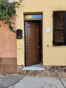 een houten deur van een gebouw met een raam bij Casa Elce in Iglesias