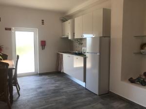 a kitchen with white cabinets and a refrigerator at Casa 1-Quinta dos Penedos in Portalegre