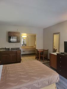 ein Hotelzimmer mit einem großen Bett und einer Küche in der Unterkunft Baymont by Wyndham Williamsburg in Williamsburg
