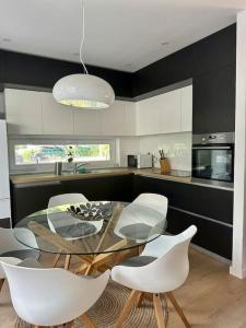 a kitchen with a glass table and white chairs at Villa Ida in Punat