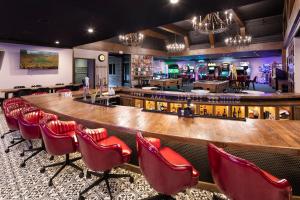 a large bar with red chairs in a room at The Highlander Hotel in Iowa City