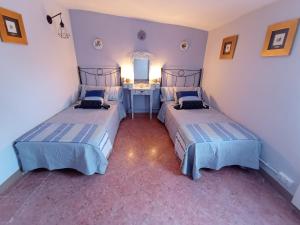 1 dormitorio con 2 camas y lavamanos en Cal Masot del Gaià, en Aiguamurcia