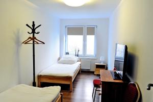 1 Schlafzimmer mit 2 Betten, einem Schreibtisch und einem TV in der Unterkunft Korona in Elblag