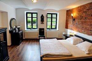 a bedroom with a bed and a brick wall at Korona in Elblag