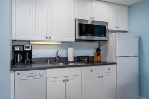 a kitchen with a sink and a microwave and a refrigerator at Harbour House stunning Studio in Fort Myers Beach +4 photos
