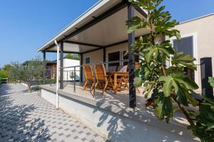 un porche de una casa con sillas y mesa en Mobile House KASTANJOLA, en Biograd na Moru