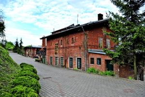 un viejo edificio de ladrillo rojo al lado de una calle en Korona, en Elbląg