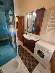 uma casa de banho com uma máquina de lavar roupa e um lavatório em Casa Elce em Iglesias