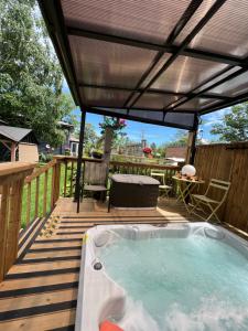 a hot tub on a deck with a pergola at Adrians Wasaga Beach in Wasaga Beach