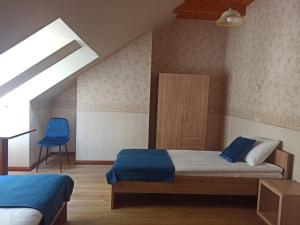 1 dormitorio con 2 camas y silla azul en Bed&Blues en Vilna