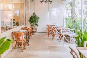 um restaurante com mesas de madeira, cadeiras e plantas em Ipanema Inn Hotel no Rio de Janeiro