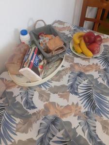 stół z dwoma talerzami jedzenia i owoców na nim w obiekcie Μεζονέτα - Διώνη- στις Άνω Αρχάνες με οντά w mieście Archanes