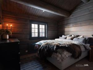 een slaapkamer met een bed met houten wanden en een raam bij Luxury log cabing, cross-country ski-in out, familiy getaway in great location in Geilo