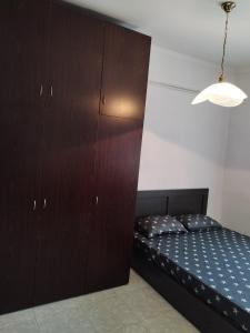 1 dormitorio con 1 cama y un gran armario de madera en ΚΛΕΟΠΑΤΡΑ en Sfendámion