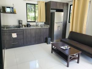 uma cozinha e sala de estar com um sofá e uma mesa em One Life Villas em Playa Avellana