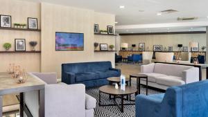 a lobby with blue couches and tables and chairs at Holiday Inn Express Leigh - Sports Village by IHG in Leigh