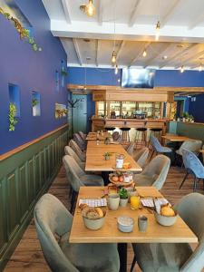 Hotel Leopold في بروج: غرفة طعام مع طاولات وكراسي خشبية