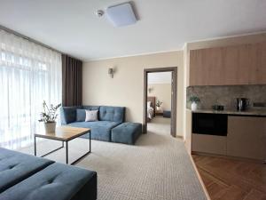 a living room with a blue couch and a kitchen at Blueberryhouse in Bukovel