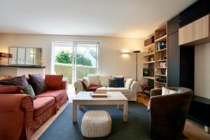 a living room with two couches and a table at Logis Magnolia in Ploemeur