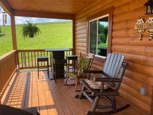 a porch of a cabin with chairs and a table at Lily Pad Cabin in South Park