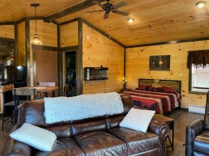 a living room with a leather couch and a bed at Lily Pad Cabin 