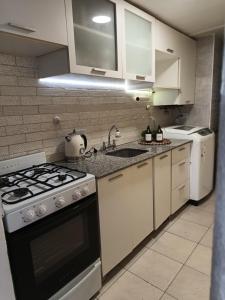 a kitchen with white cabinets and a stove top oven at HERMOSO DPTO 2 dor TUCUMAN in San Miguel de Tucumán