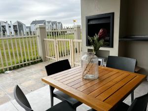 a vase of flowers on a wooden table on a balcony at Mo's Explorer Cape Town Vacation Apartment in Cape Town