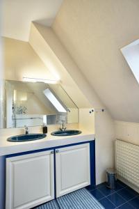 a bathroom with two sinks and a mirror at Logis Magnolia in Ploemeur