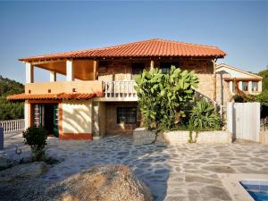 a house with a tile roof and a patio at Encontro no Rio in Póvoa de Midões