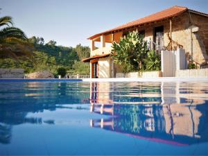a swimming pool in front of a house at Encontro no Rio in Póvoa de Midões