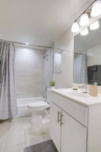 bagno bianco con servizi igienici e lavandino di Luxury Condo in the heart of Crystal City ad Arlington