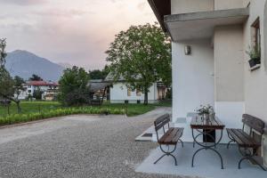 zwei Bänke und ein Tisch an der Seite eines Gebäudes in der Unterkunft Apartment For You in Bled