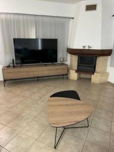 a living room with a large television and a chair at גבוה בגלבוע in Gan Ner