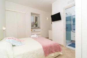 a bedroom with a bed and a tv and a bathroom at Casetta Lucia in Massa Lubrense
