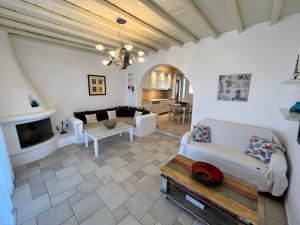 a living room with white furniture and a fireplace at Villa Alba Mykonos in Agios Sostis Mykonos