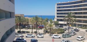 a view of a parking lot with palm trees and a building at Ibiscus Hotel in Rhodes Town
