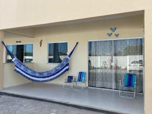 a building with a hammock on the side of it at DUNAS RESIDENCE CASA 13 Santo Amaro - Lençóis Maranhenses in Santo Amaro