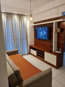 uma sala de estar com uma televisão de ecrã plano e um sofá em Condomínio mais Maracanã BL 1 AP 111 no Rio de Janeiro