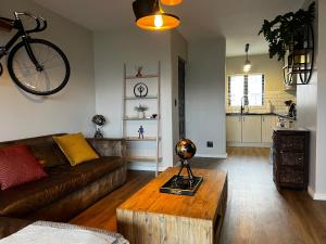 a living room with a couch and a bicycle on the wall at Mo's Explorer Cape Town Vacation Apartment in Cape Town