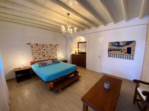 sypialnia z niebieskim łóżkiem i stołem w obiekcie Villa Alba Mykonos w mieście Agios Sostis Mykonos