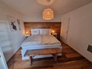 a bedroom with a large bed with a wooden headboard at Charmantes Eifel Ferienhaus an der Schavener Heide in Mechernich