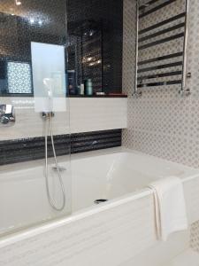 eine weiße Badewanne mit Dusche im Bad in der Unterkunft Villa Solva in Golubinoye