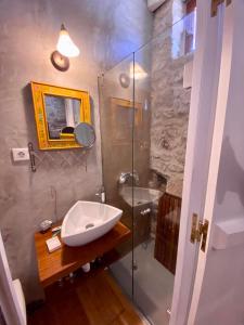 a bathroom with a sink and a glass shower at Monastery View House in Mandrakion